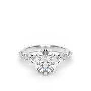 White Gold Round Shape Diamond Side Stone Engagement Ring With Shared Prong Setting.
